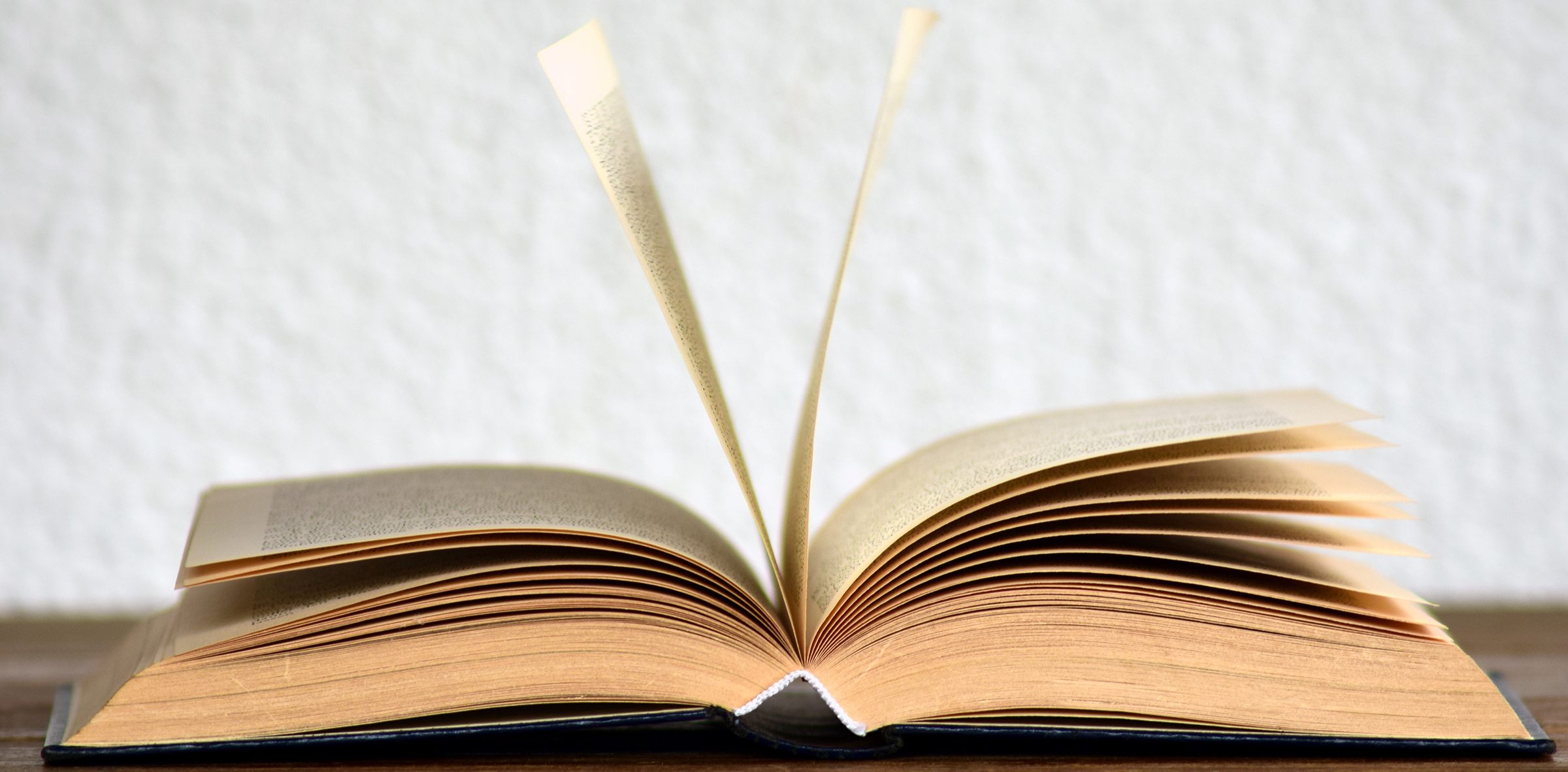 Hardback book sitting open in the middle on a table